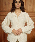 Woman wearing a cream embroidered blouse