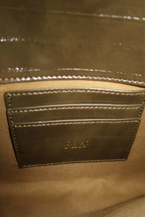 Close-up of a olive green leather clutch with cardholder compartment inside
