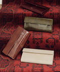 Four leather clutch in brown, olive green, burgundy and vanilla