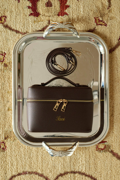 Brown handbag with gold accents and a crossbody straps