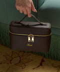 Brown handbag with gold zipper and 'saoi' branding on a textured surface.